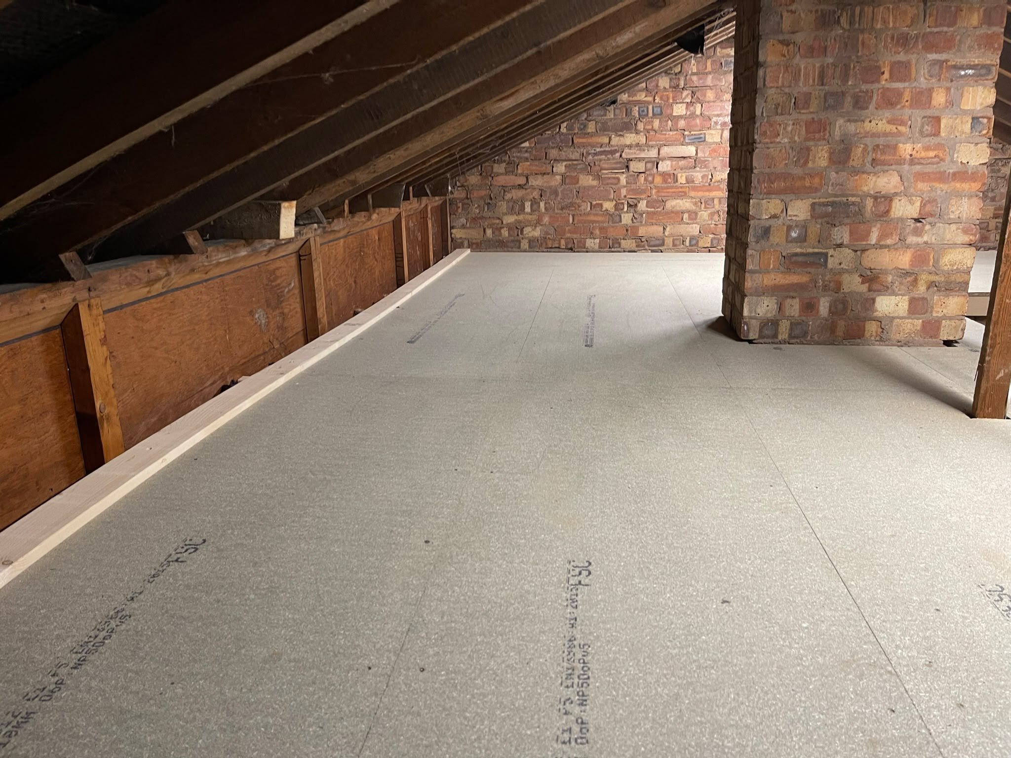 Boarded loft storage beside brick eaves