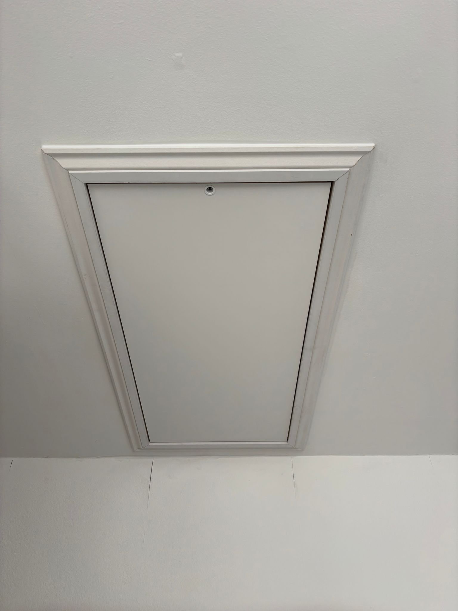 Clean finished loft hatch fitted into a ceiling